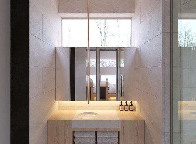 This stunning bathroom boasts a minimalist design with light beige tiles and wooden vanity.
