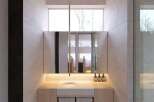 This stunning bathroom boasts a minimalist design with light beige tiles and wooden vanity.