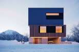 Stunning modern home nestled in a snowy landscape, featuring a sleek blue and wood exterior.