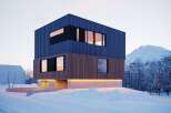 Stunning modern home nestled in a snowy mountain landscape.