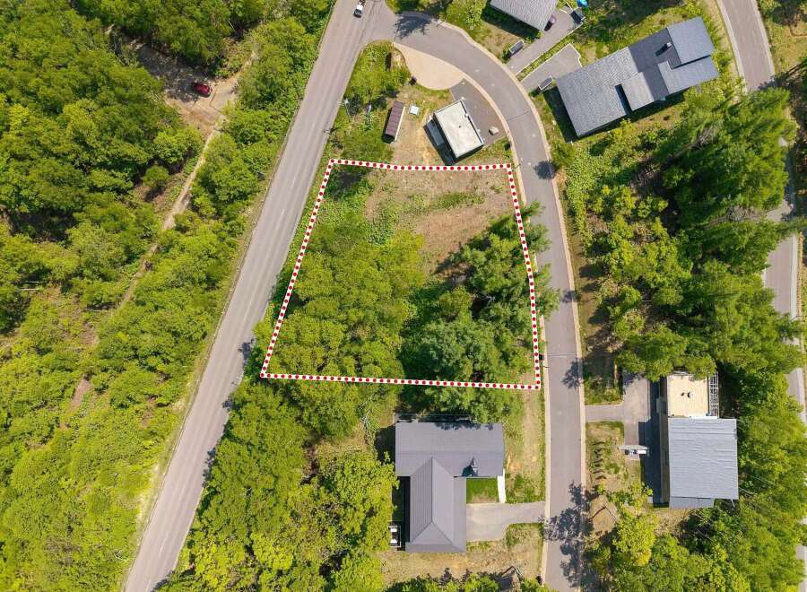 Nestled in a wooded area, this lot offers a tranquil setting with easy access to roads.