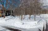 This stunning property boasts a modern, architecturally unique home nestled in a snowy, wooded landscape.