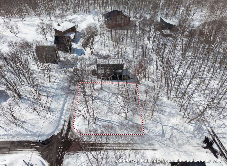 Nestled in a snowy landscape, this property offers a secluded setting with mature trees.
