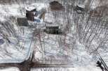 Nestled in a snowy landscape, this property offers a secluded setting with mature trees.