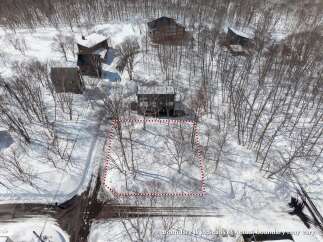 Nestled in a snowy landscape, this property offers a secluded setting with mature trees.