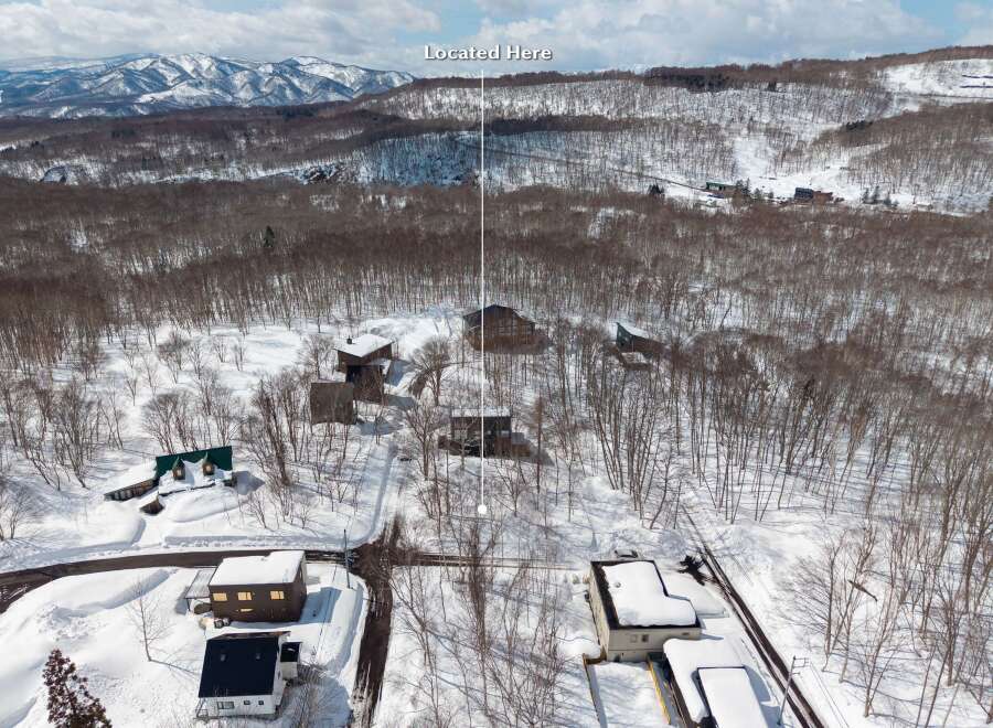 Nestled in a snowy mountainside forest, this secluded property offers breathtaking views and serene surroundings.