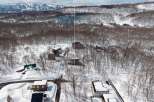 Nestled in a snowy mountainside forest, this secluded property offers breathtaking views and serene surroundings.