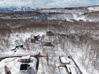 Nestled in a snowy mountainside forest, this secluded property offers breathtaking views and serene surroundings.