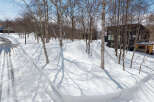 This stunning property boasts a modern, black-exterior home nestled amongst snow-covered trees.