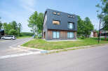 Modern house with dark gray metal siding and wood accents.
