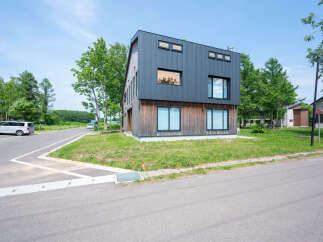 Modern house with dark gray metal siding and wood accents.
