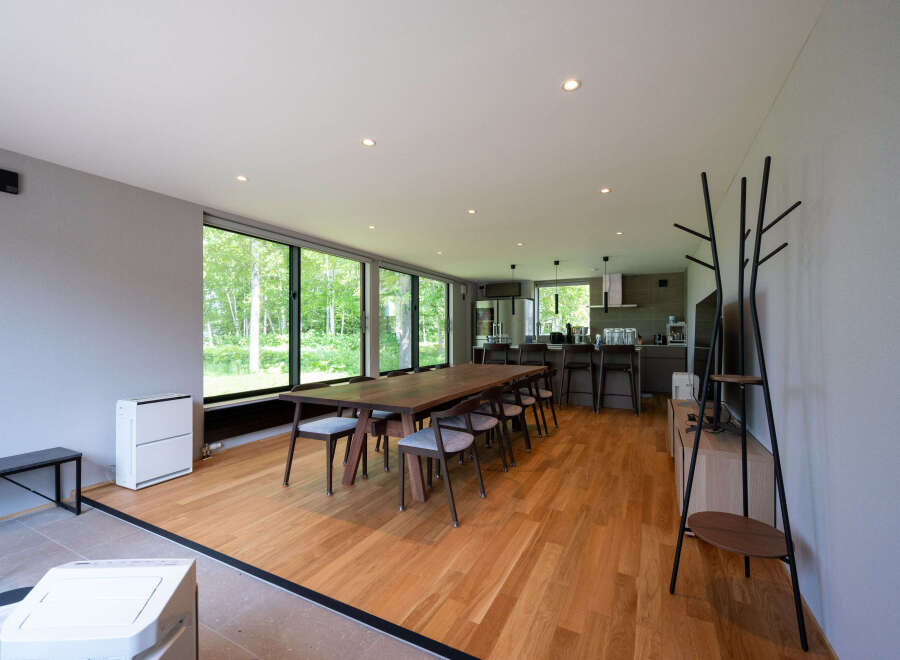 This stunning property boasts a spacious open-plan living area with floor-to-ceiling windows offering breathtaking views of the surrounding forest.