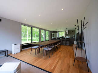 This stunning property boasts a spacious open-plan living area with floor-to-ceiling windows offering breathtaking views of the surrounding forest.