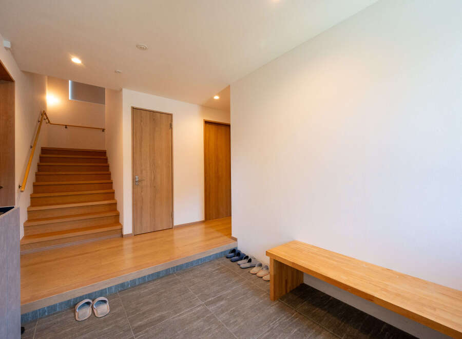 This stunning property boasts a spacious entryway with a built-in wooden bench, perfect for putting on and taking off shoes.