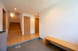 This stunning property boasts a spacious entryway with a built-in wooden bench, perfect for putting on and taking off shoes.