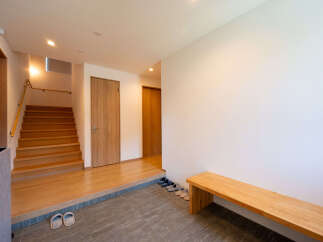 This stunning property boasts a spacious entryway with a built-in wooden bench, perfect for putting on and taking off shoes.