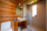 This modern bathroom boasts a sleek design with wood paneling and a glass-enclosed shower.