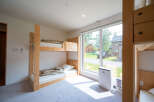 Bright and airy room with a bunk bed and large window overlooking a residential street.