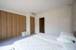 This bright and airy bedroom features a clean, minimalist design.