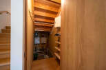 This home boasts a unique under-stair storage area, complete with built-in shelving and ample space for various items.