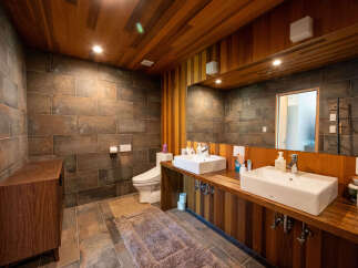 This stunning bathroom boasts a unique blend of rustic wood and modern tile, creating a serene and stylish atmosphere.