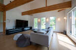 This stunning home boasts an open-concept living area with high ceilings and exposed wooden beams, creating a warm and inviting atmosphere.