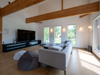 This stunning home boasts an open-concept living area with high ceilings and exposed wooden beams, creating a warm and inviting atmosphere.