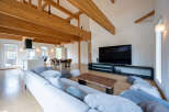 This stunning home boasts an open-concept living area with high ceilings and exposed wooden beams, creating a warm and inviting atmosphere.