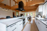 This stunning kitchen boasts a spacious island with sleek white cabinetry and modern black hardware.