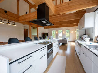 This stunning kitchen boasts a spacious island with sleek white cabinetry and modern black hardware.