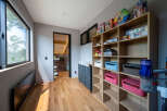 This stunning property boasts a dedicated playroom, complete with built-in shelving for games and toys, creating a fun and organized space for children.