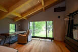 Relax and unwind in this serene bedroom featuring a large window overlooking a lush green landscape.