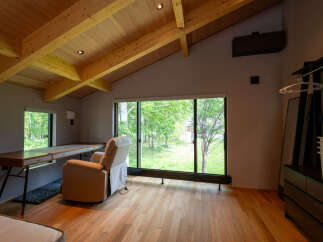 Relax and unwind in this serene bedroom featuring a large window overlooking a lush green landscape.