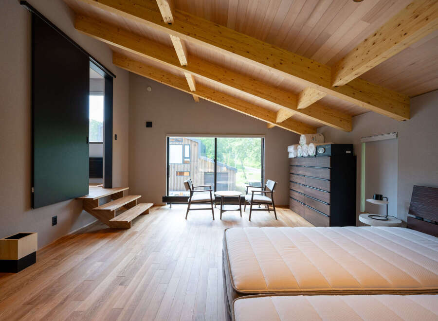 This stunning bedroom boasts a spacious layout with a cozy sitting area and large windows offering breathtaking views.