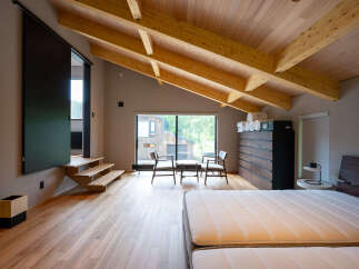 This stunning bedroom boasts a spacious layout with a cozy sitting area and large windows offering breathtaking views.