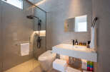 Modern bathroom with a glass shower enclosure, sleek fixtures, and ample storage.