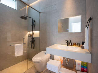 Modern bathroom with a glass shower enclosure, sleek fixtures, and ample storage.