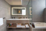 This luxurious bathroom boasts a double vanity with sleek, modern fixtures and ample storage.