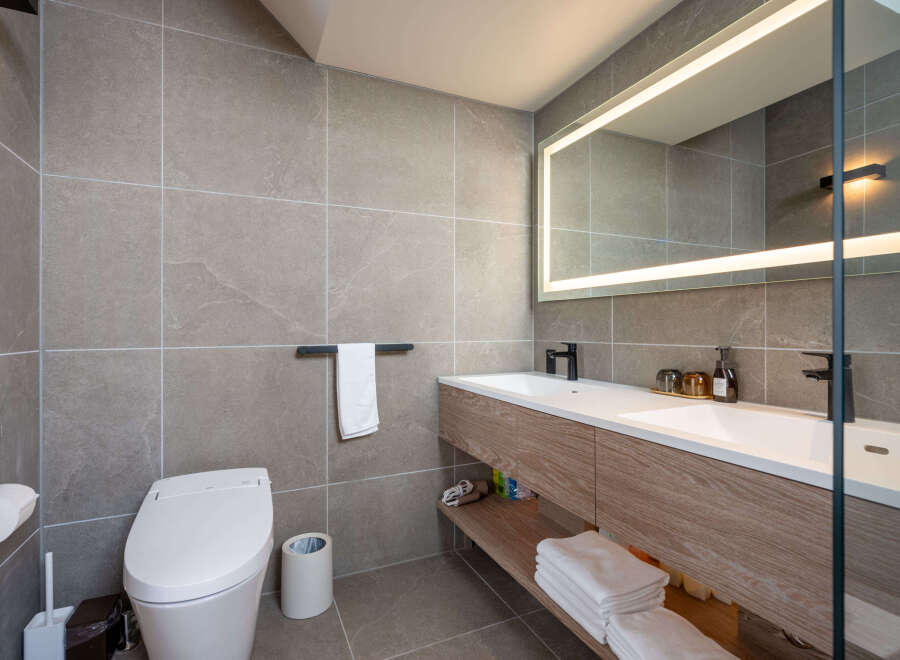 Modern bathroom with double vanity, sleek fixtures, and a smart toilet.
