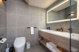 Modern bathroom with double vanity, sleek fixtures, and a smart toilet.