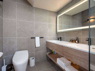 Modern bathroom with double vanity, sleek fixtures, and a smart toilet.