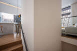 Modern staircase design with sleek metal railing and hardwood steps leading to an open-concept living area.