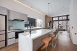 This stunning modern kitchen boasts a sleek design with concrete-look cabinetry and a stunning marble island.