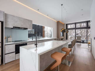 This stunning modern kitchen boasts a sleek design with concrete-look cabinetry and a stunning marble island.