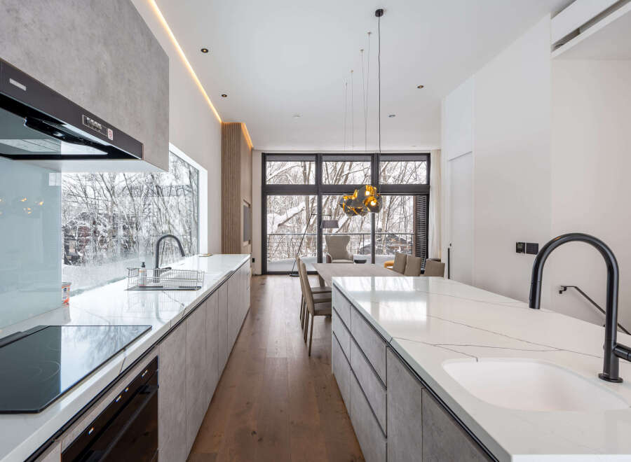 Modern kitchen with marble countertops and stainless steel appliances.