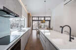 Modern kitchen with marble countertops and stainless steel appliances.