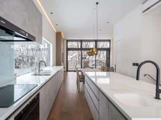 Modern kitchen with marble countertops and stainless steel appliances.