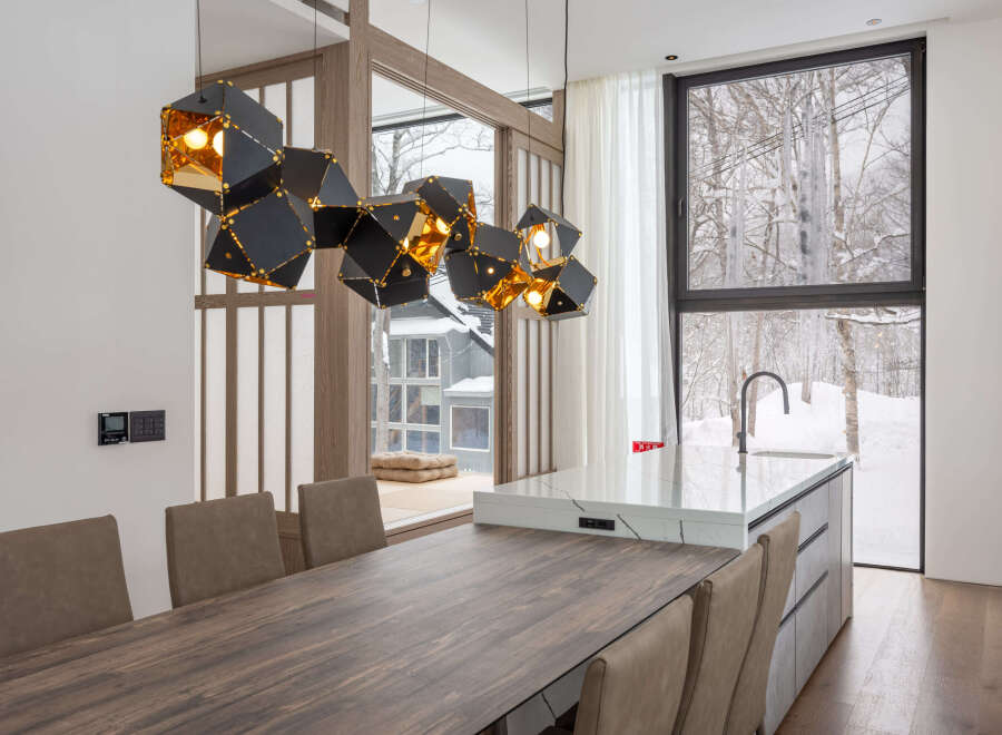 Modern kitchen with stunning mountain views and a unique geometric light fixture.