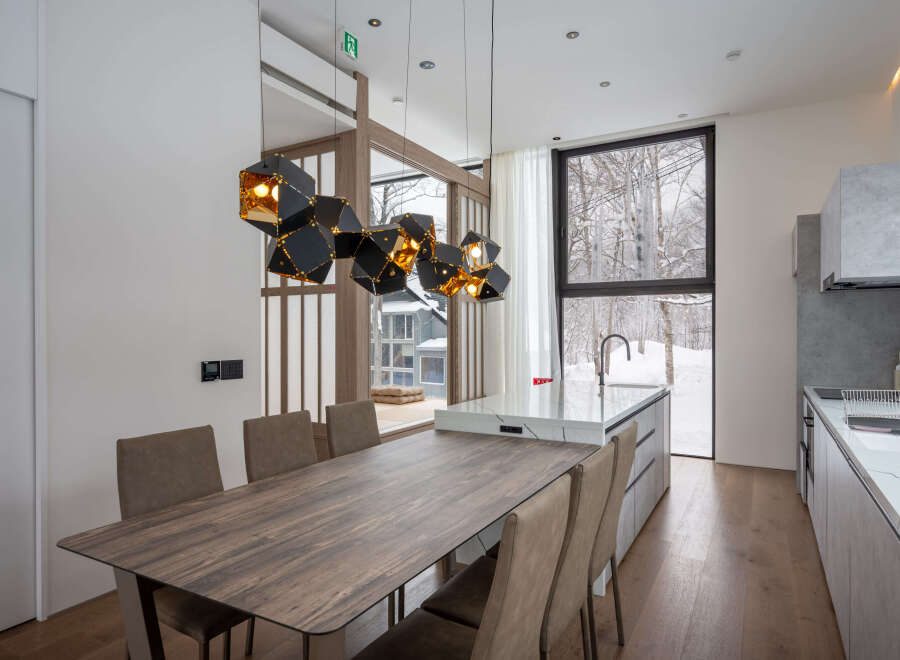 This stunning property boasts a modern, open-plan kitchen and dining area with breathtaking views of a snow-covered landscape.