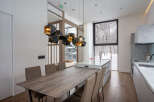 This stunning property boasts a modern, open-plan kitchen and dining area with breathtaking views of a snow-covered landscape.